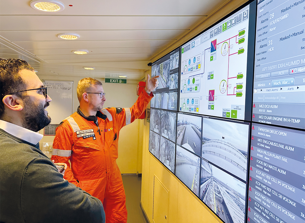 The HEROSE Area Sales Manager and AIDAnova Staff Chief Engineer in front of the engine control displays in the engine control room.